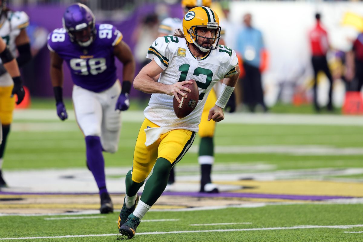 Aaron Rodgers scrambles with the ball