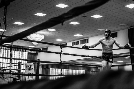 A tired boxer standing in the corner of the ring.