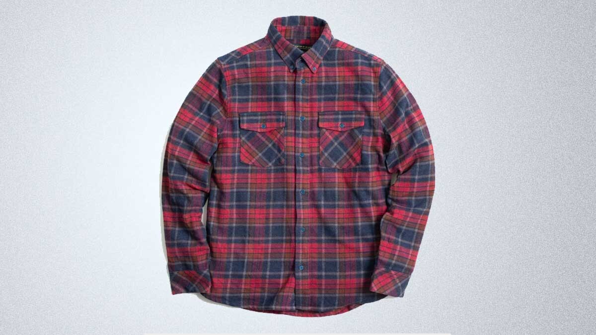 Red and blue United By Blue flannel on a gray background