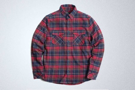 Red and blue United By Blue flannel on a gray background