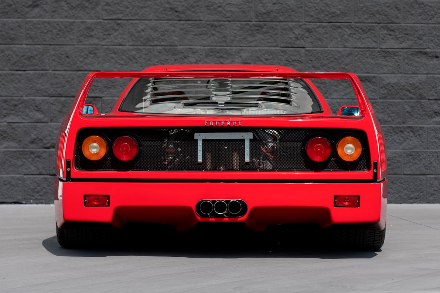 The rear end of a 1992 Ferrari F40 sports car in red (Rosso Corsa) that's up for auction at the Mecum Auctions Kissimmee, Florida sale in January 2022