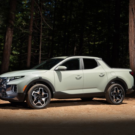 The 2022 Hyundai Santa Cruz, a new small pickup truck for the American market, sitting in an illuminated spot in the middle of a forest