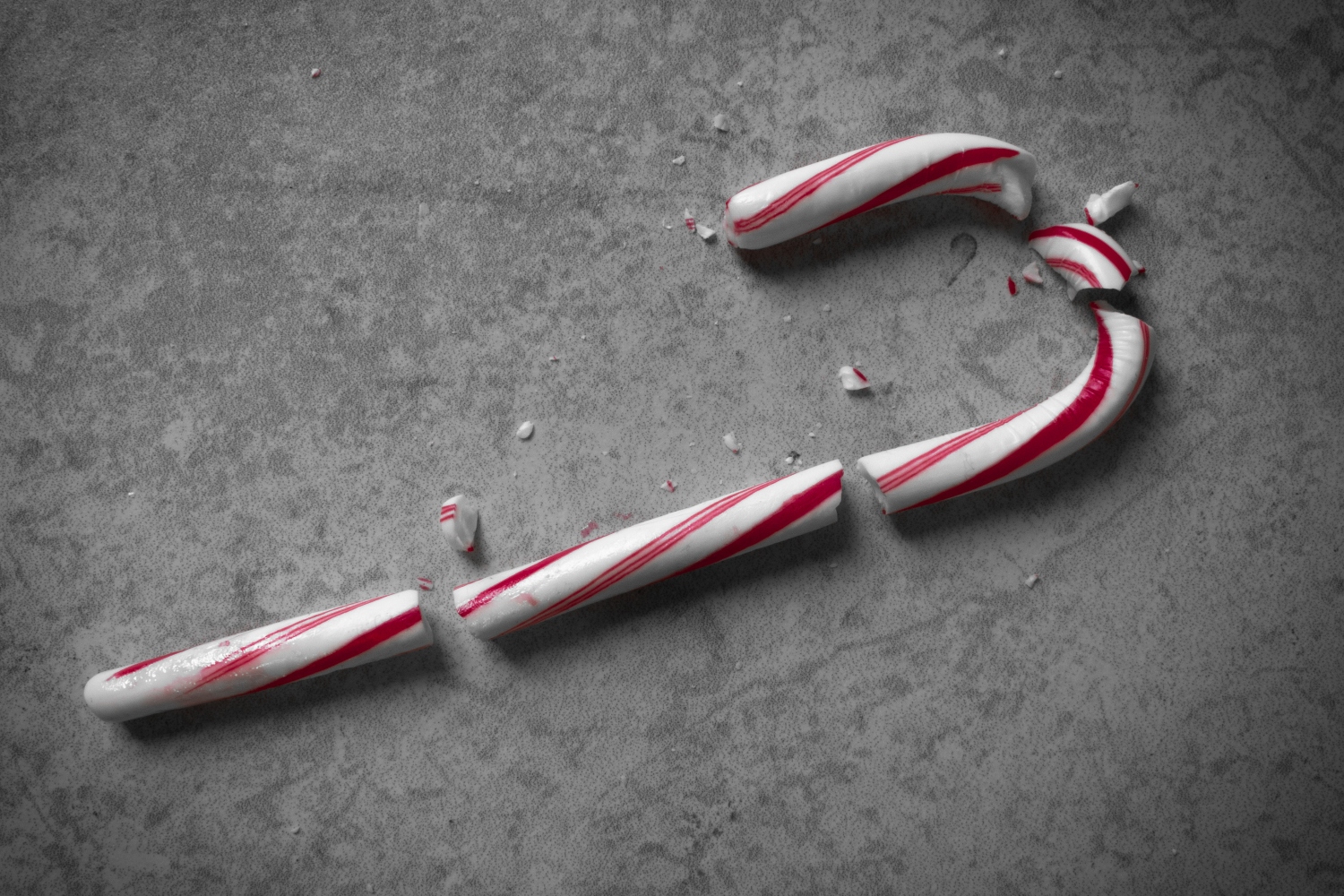 Moody Top-Down Shot of a Red and White Candy Cane that has Been Shattered into Multiple Pieces. Due to Covid and supply chain issues, there is a candy cane shortage this year.