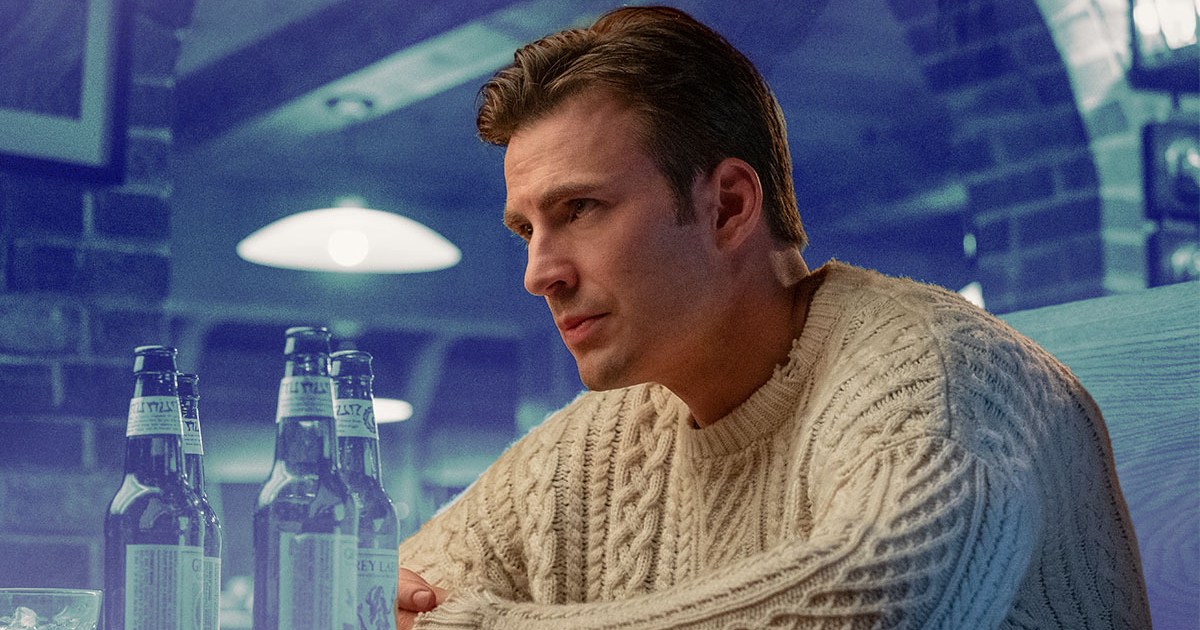 Chris Evans in the movie Knives Out wearing a white fisherman sweater on a blue toned background