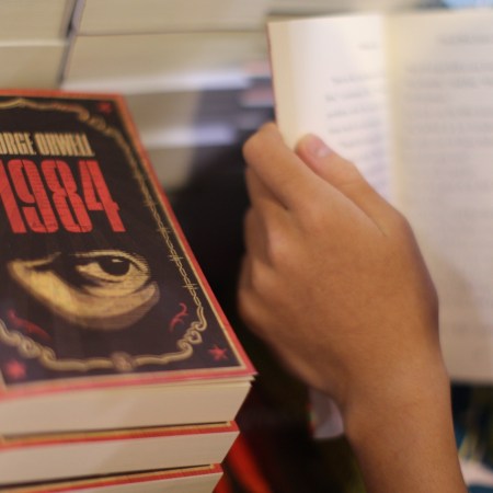A boy reads a book next to copies of British writer George Orwell's 1984 at Hong Kong's annual book fair on July 15, 2015.