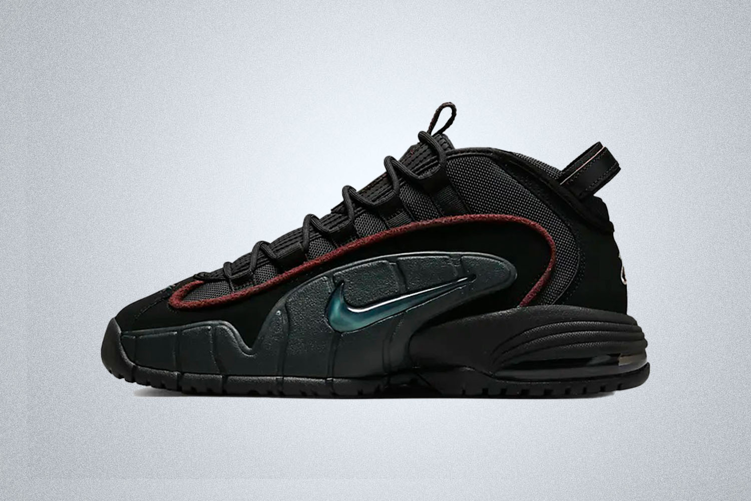 a black Nike Air Max Penny on a grey background