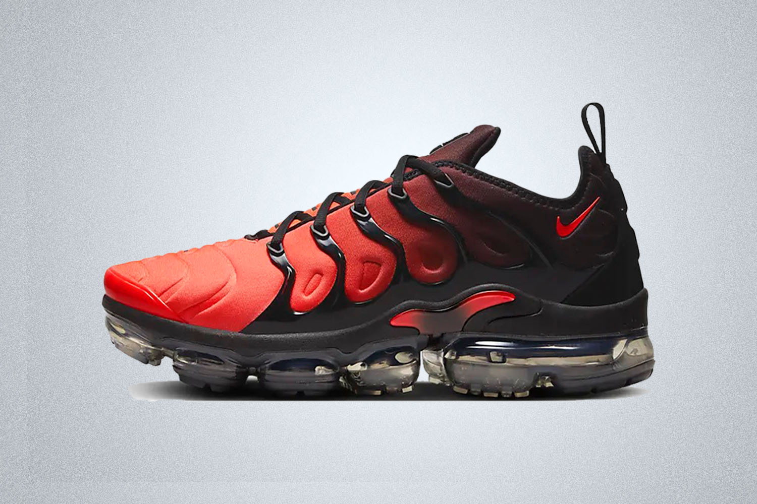 a black and red Nike Air Max VaporMax Plus on a grey background