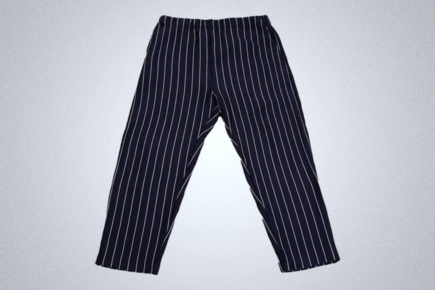 a pair of blue pinstriped pants from The Elder Statesman on a grey background