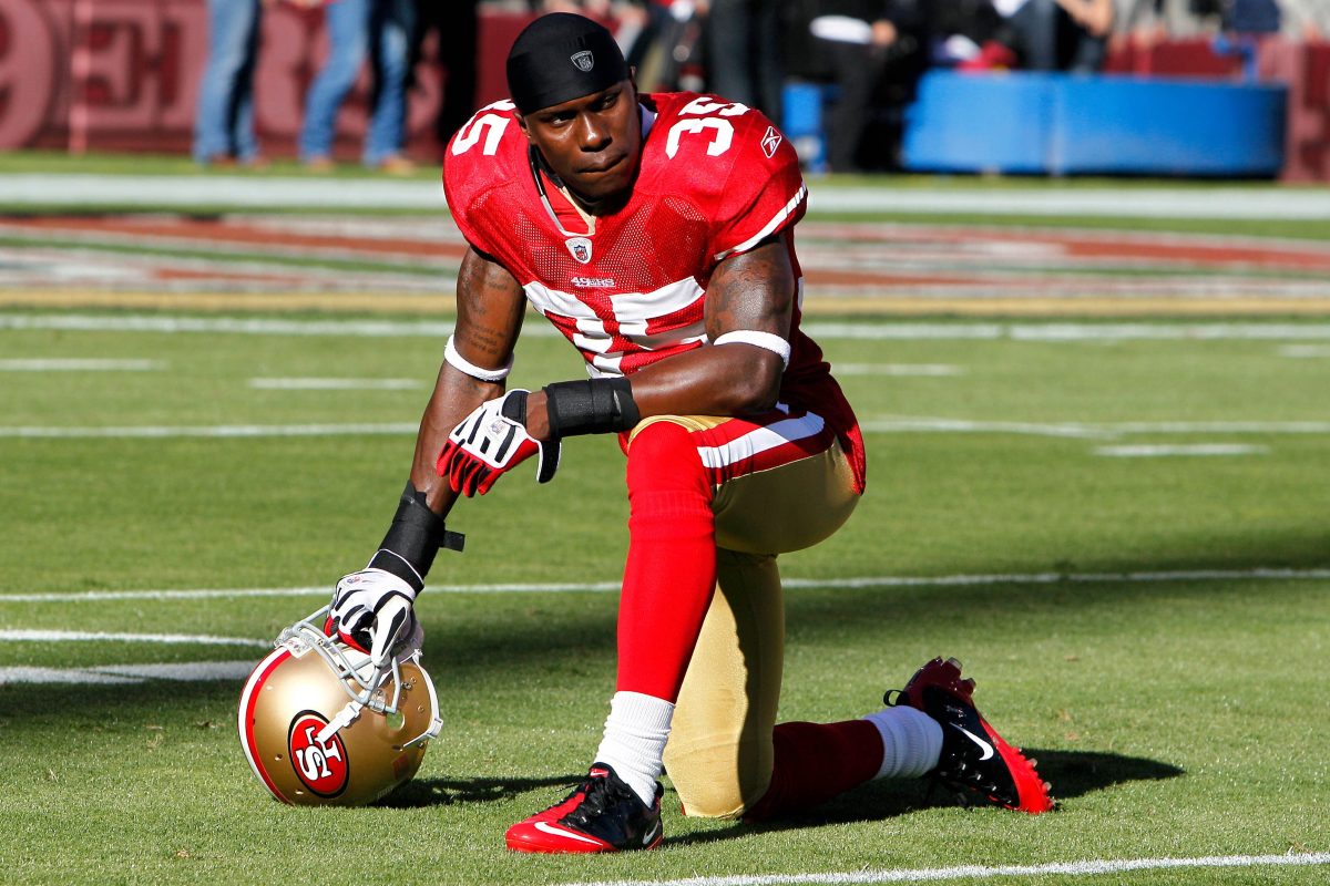 Late NFL player Phillip Adams kneels during a game between the New Orleans Saints and the San Francisco 49ers