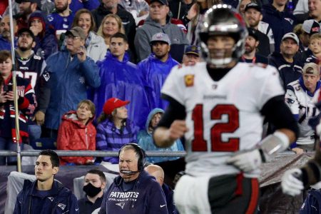 Bill Belichick looks on as Tom Brady runs past in his Buccaneers uniform