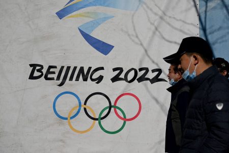 People walk past the Beijing 2022 Winter Olympics logo at Shougang Park