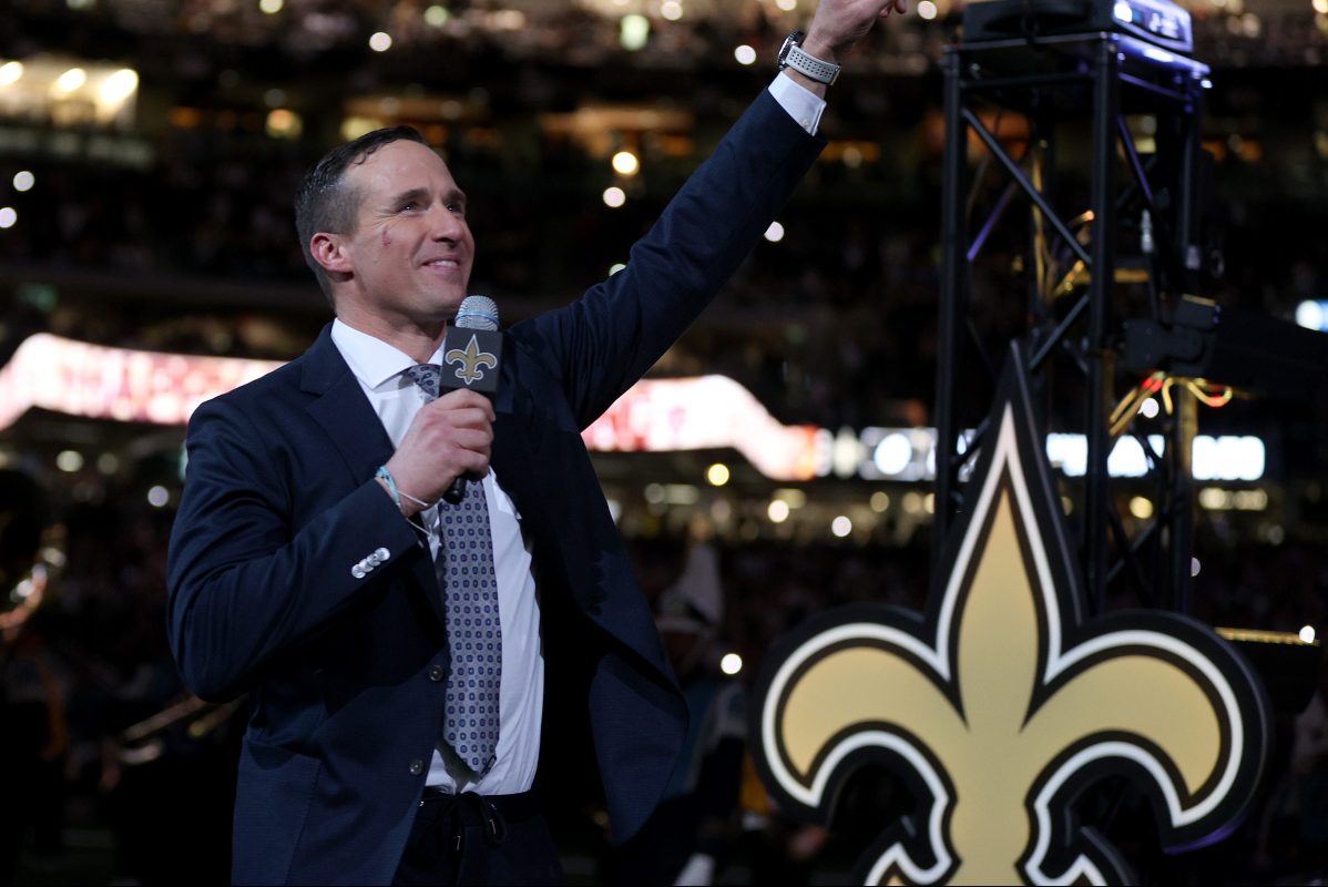 Ex-New Orleans Saints quarterback Drew Brees speaks to fans during halftime of a game. The retired QB was almost coaxed into playing this week due to injuries on the team.