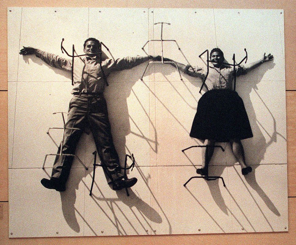 A photo mural of designers Charles and Ray Eames