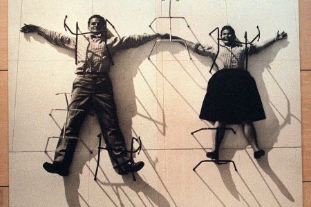 A photo mural of designers Charles and Ray Eames