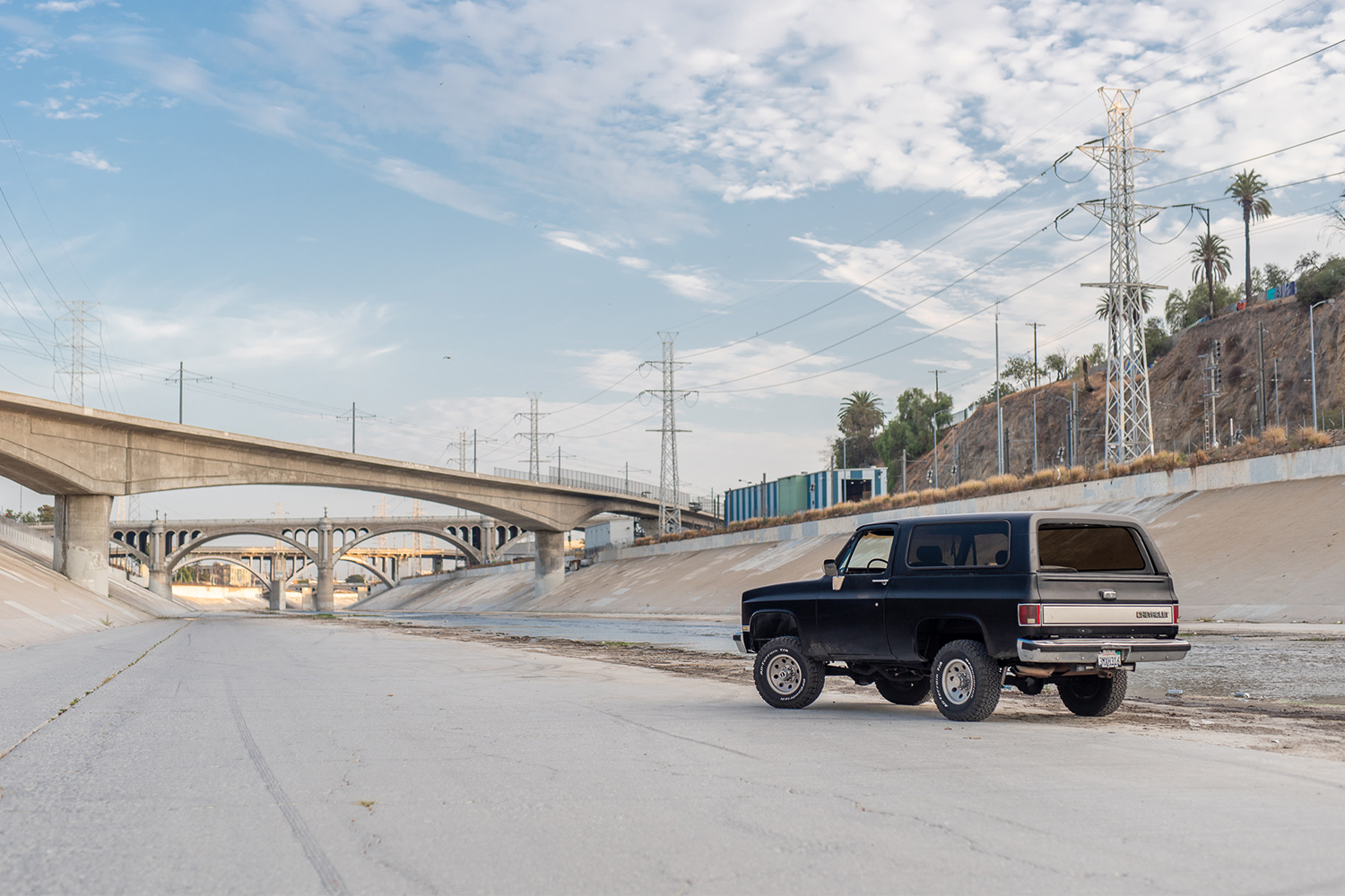 A black 1988 Chevy K5 Blazer sitting in the middle of the Los Angeles River. The restored classic SUV is owned by Kyle Cheromcha.
