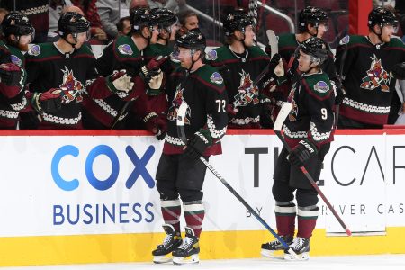 Travis Boyd of the Arizona Coyotes celebrates with teammates on the bench after scoring a goal at Gila River Arena