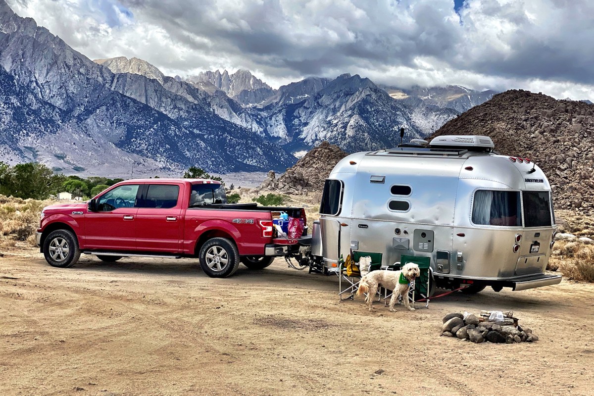 A red Ford F-150 towing an Airstream trailer in the mountains. Millennials are now buying more pickup trucks in the U.S. than Boomers and Gen X in 2021.