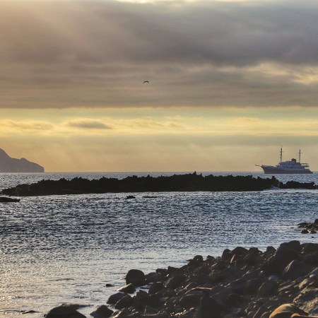 An expedition vessel called the M/V Evolution meanders its way through the Galápagos Islands