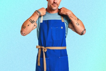 The Cobalt Blue kitchen apron from Hedley & Bennett on a tattooed man. The aprons are on sale this December 2021 and make for perfect Christmas and holiday presents.