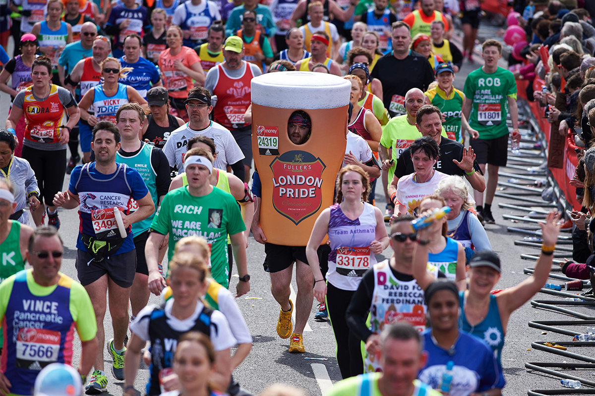 A man running a race dressed as a beer.