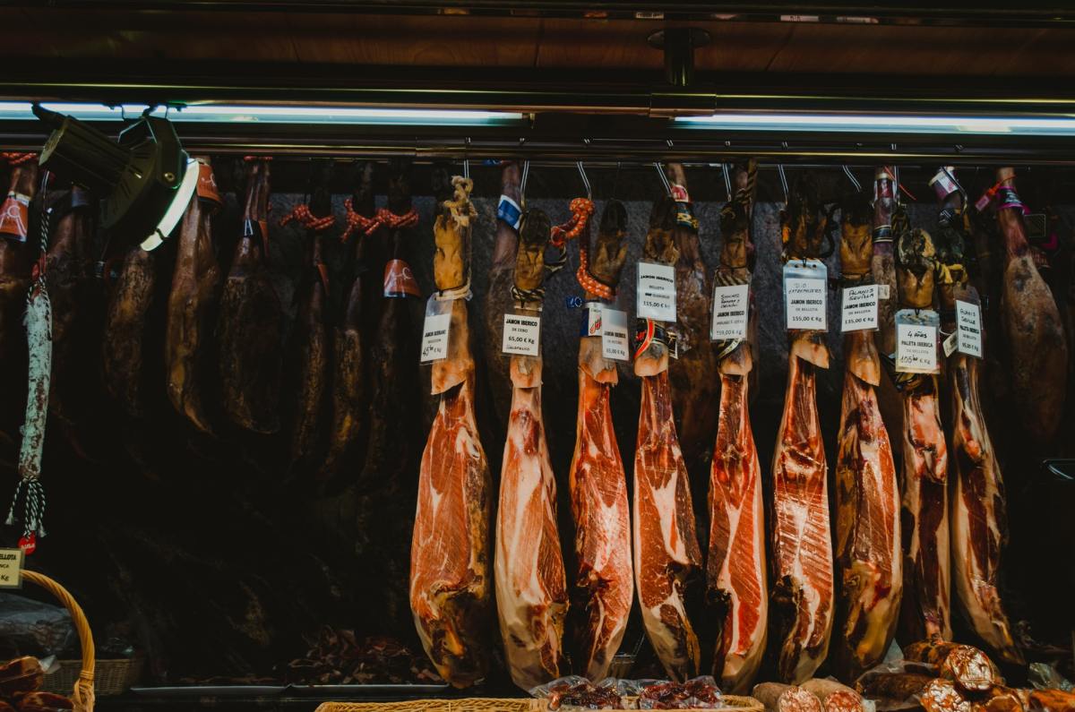 A rack of hams handing in a shop. In Spain, ham sniffers are employed by some purveyors to determine when it's time to sell the meat.