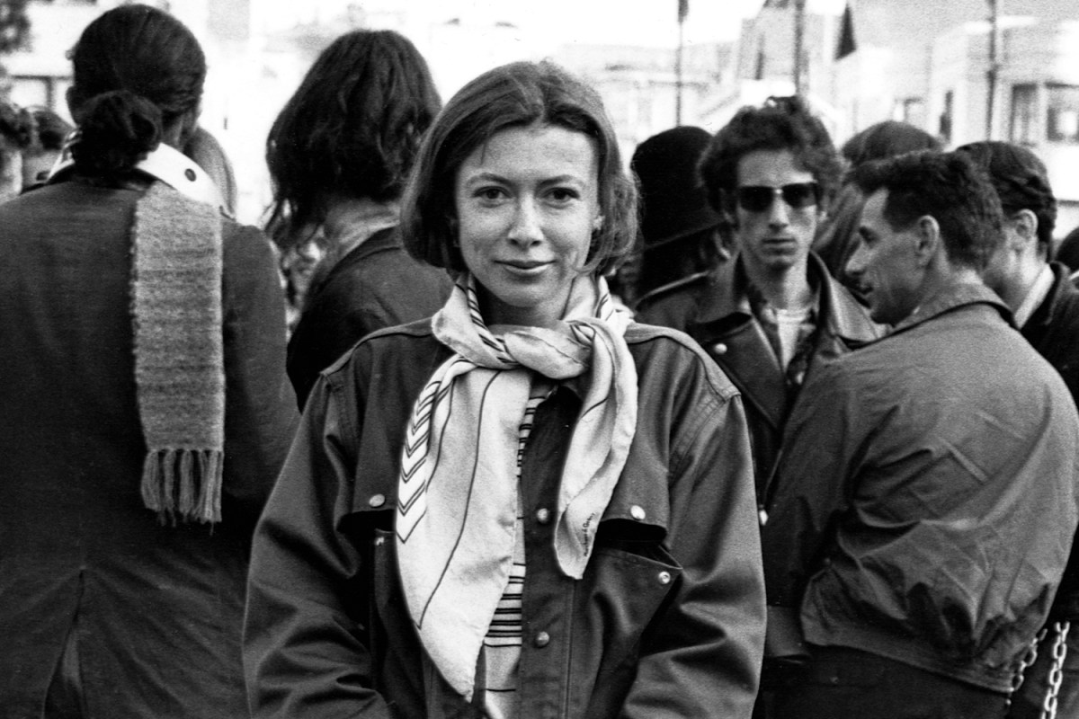 Joan Didion stands at the panhandle of Golden Gate Park with a group of hippies during the writing of her article "Slouching Towards Bethlehem" in April 1967.