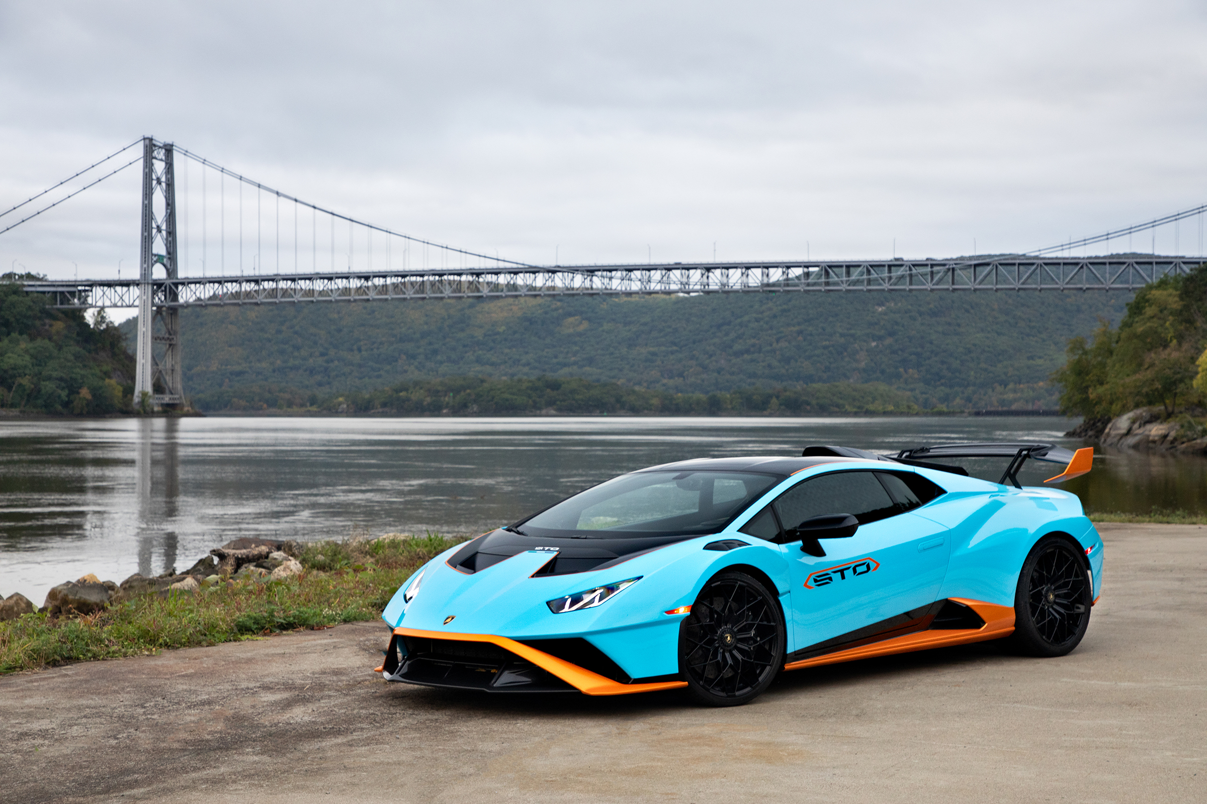 a lamborghini huracan STO sits in the shadow of a bridge in the hudson valley in new york
