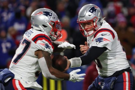Mac Jones of the New England Patriots hands the ball off to Damien Harris