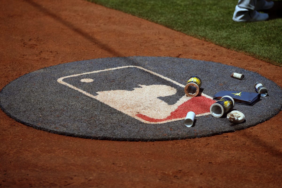 View of on deck circle with MLB logo, bat weights and a rosin bag