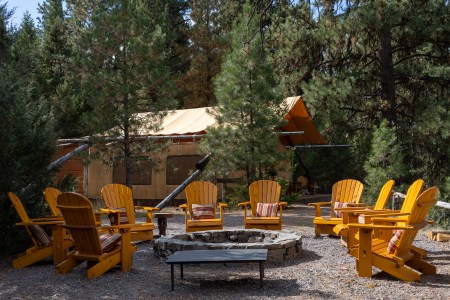 adirondack chairs around a firepit in one of the camps at the resort at paws up in montana
