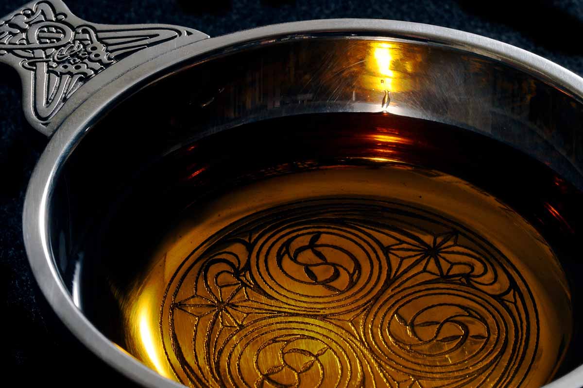 A traditional Scottish cup, a quaich, with a dram of single malt whiskey.