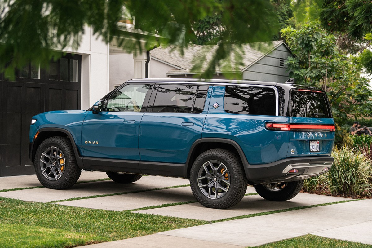The Rivian R1S SUV in blue sitting in a driveway. The EV startup announced it had made the first two deliveries of the vehicle in December 2021.