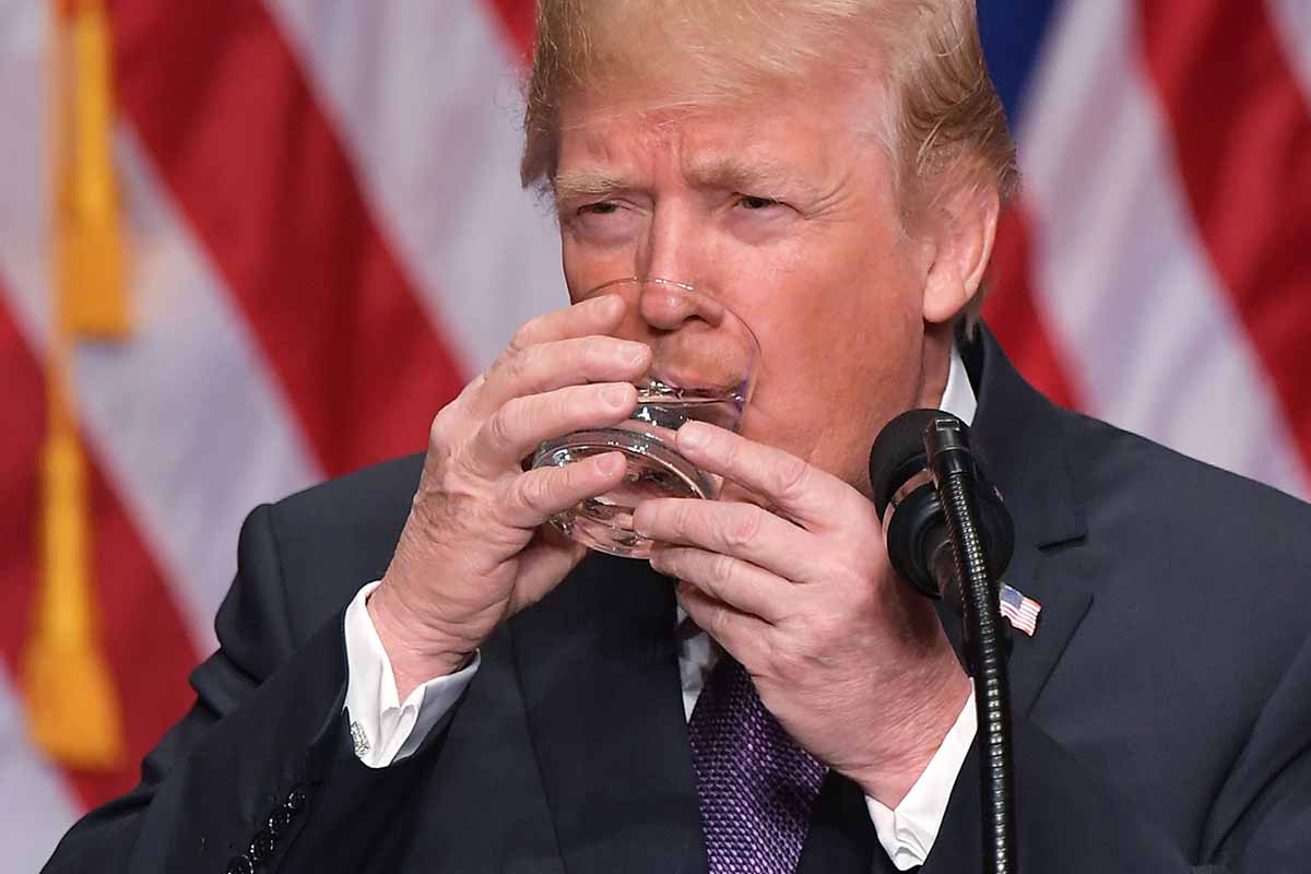 Former president Donald Trump takes a sip of water while speaking on his national security strategy at the Ronald Reagan Building in Washington, DC on December 18, 2017. There is now a Trump-themed bar in Trump Tower.