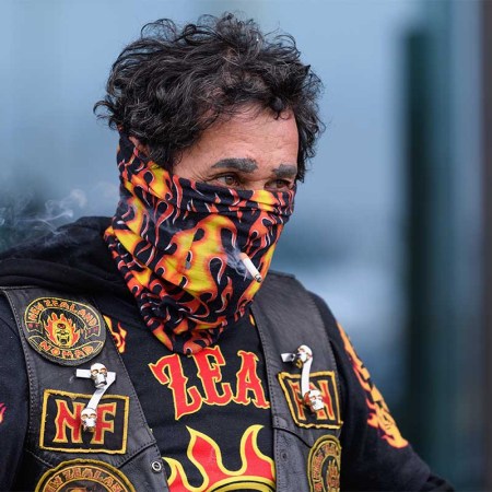 A man smokes a cigarette through his scarf on March 26, 2020 in Christchurch, New Zealand.