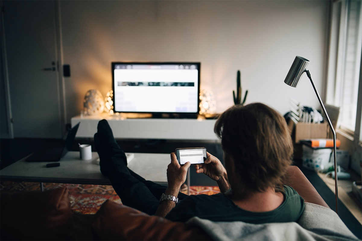 A man sitting on a couch in front of screens. A new CDC report classifies a quarter of American adults as inactive, but it's a relatively easy problem to fix.