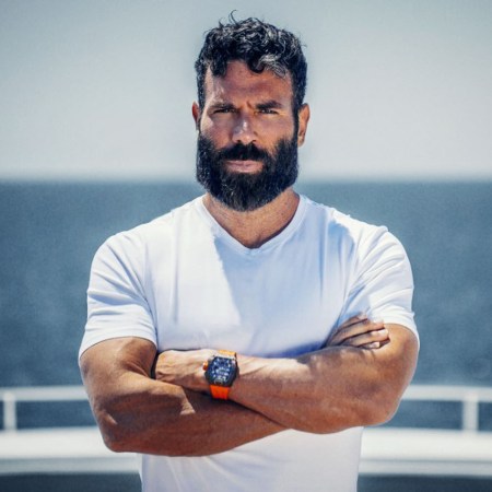 Dan Bilzerian, poker player, social media star and author of "The Setup," poses with arms crossed against a seascape