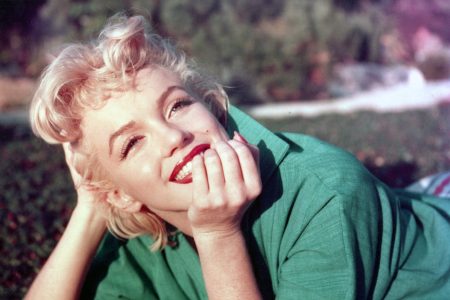 Marilyn Monroe poses for a portrait laying on the grass in 1954 in Palm Springs, California.