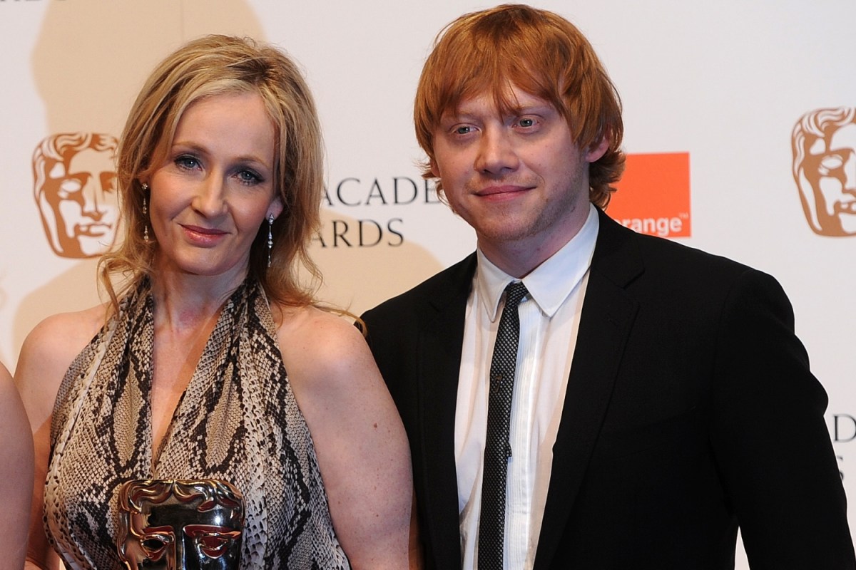 British author JK Rowling (2nd R) and producer David Hayman (L) pose for photographers with British actress Emma Watson (2nd L) and British actor Rupert Grint (R) after receiving their British Academy of Film Award (BAFTA) for 'Outstanding British Contribution to Cinema: Harry Potter' at the Royal Opera House in central London, on February 13, 2011. Grint says the author, who has been accused of being transphobic, is like a troubling "auntie."