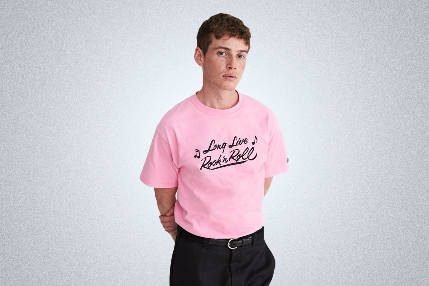 a model in. a pink graphic tee 