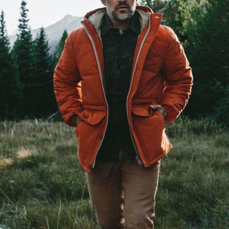 a model walking outdoors with the Taylor Stitch Whitney Parka and Camp Pants on