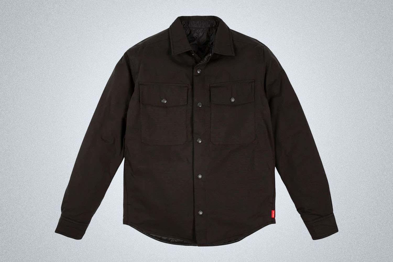 a puffed insulated Topo Designs overshirt on a grey background