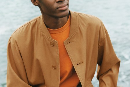 A model in an organ shirt and tan jacket