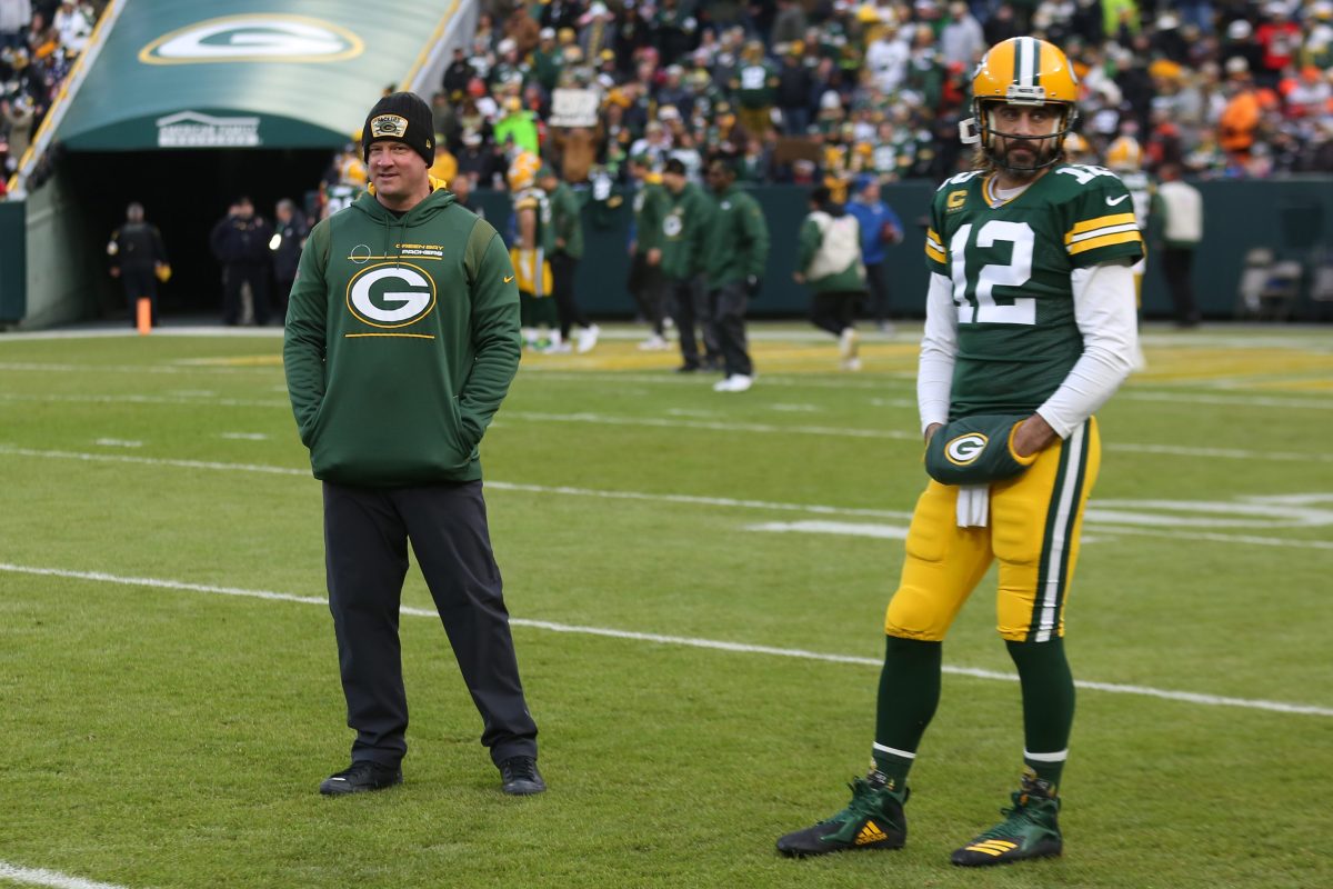 Nathaniel Hackett looks on as Green Bay Packers quarterback Aaron Rodgers warms up