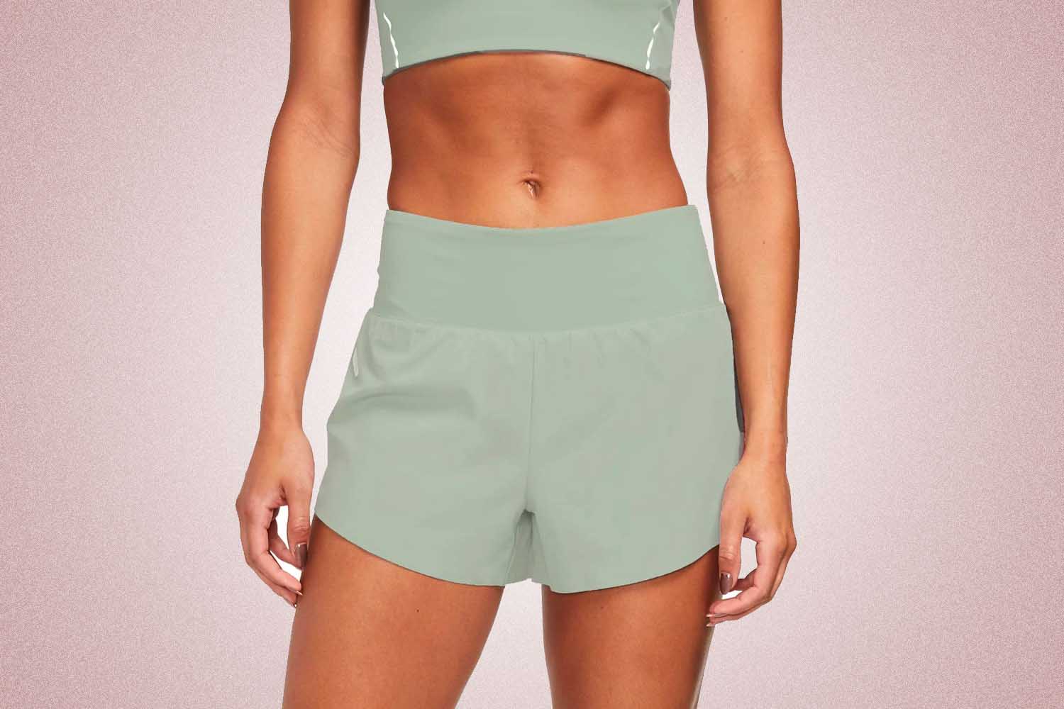 Light green running shorts from Alwrld, a perfect Valentine’s Day gift for 2022, on a pink background.