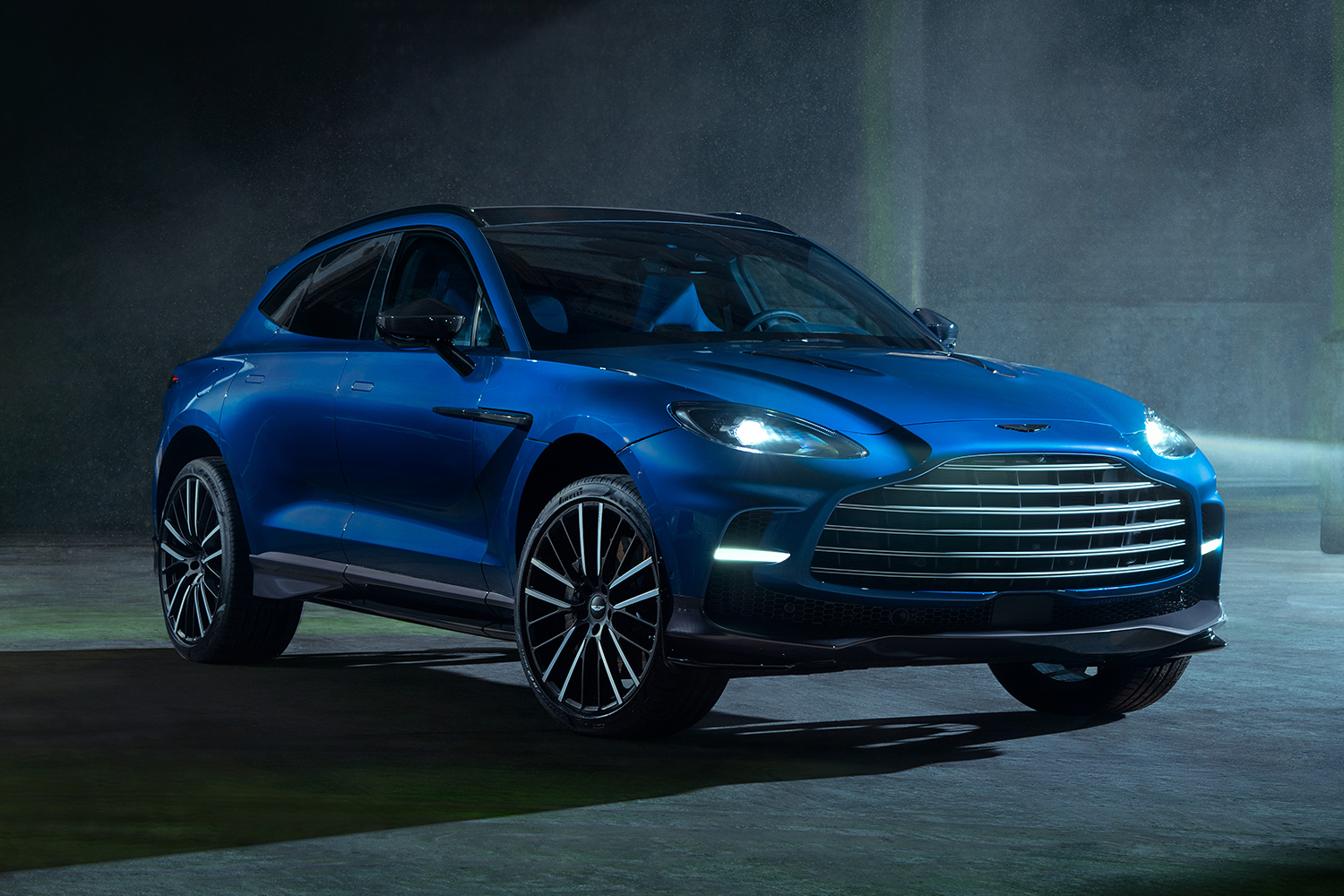 The Aston Martin DBX707 SUV, a high-performance version of the British automaker's DBX vehicle, in blue with its headlights on