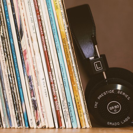a stack of old records next to a pair of stereo headphones