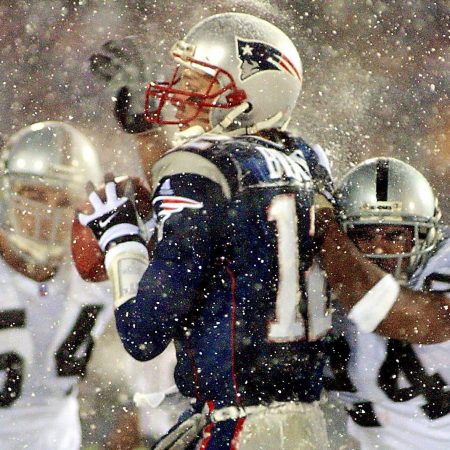 Tom Brady takes a hit from Charles Woodson of the Oakland Raiders in a 2002 AFC playoff game