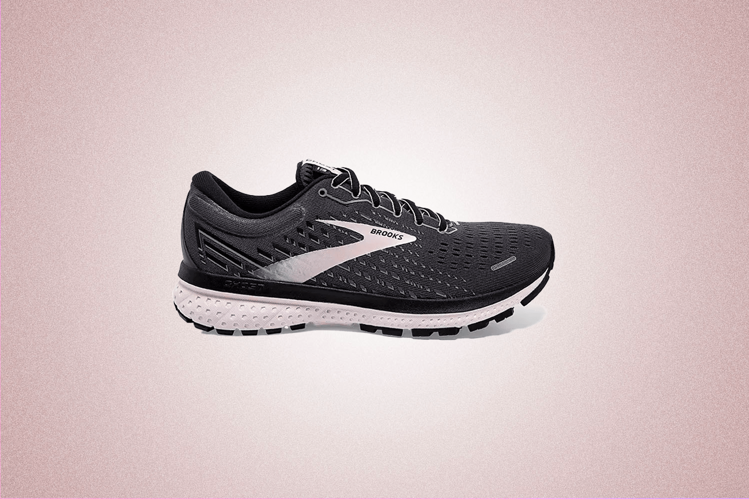 Black and white training sneaker from Brooks, a perfect Valentine’s Day gift for 2022, on a pink background.