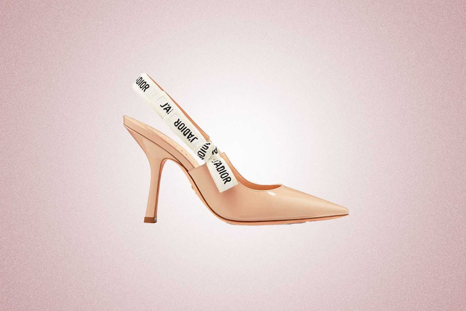 Nude patent calfskin pumps from Dior with a embroidered 'J'ADIOR' ribbon on the back, a perfect Valentine’s Day gift for 2022, on a pink background.