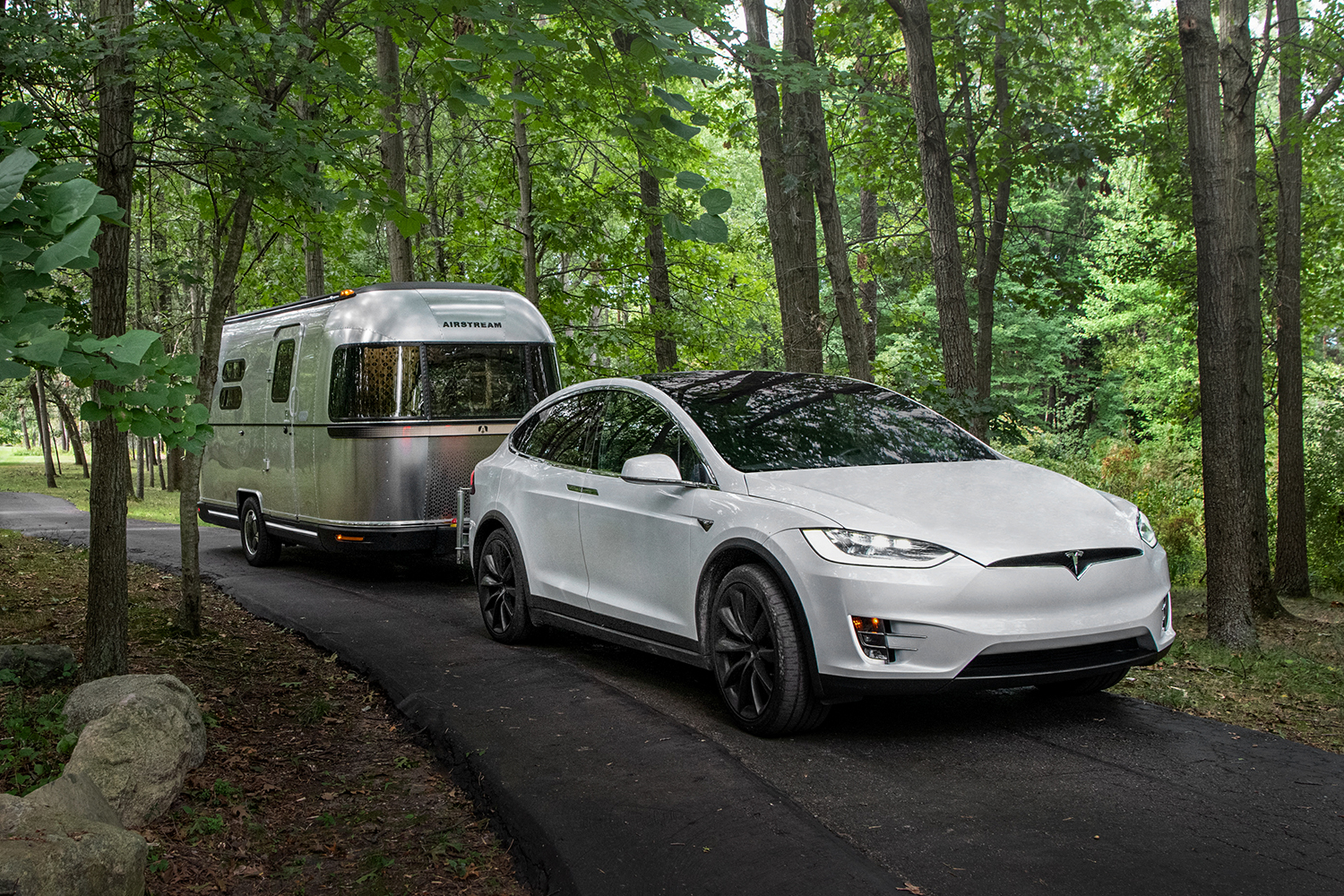 The Airstream eStream electric concept silver bullet trailer being towed by a Tesla. The electric drivetrain helps alleviate the load on the EV and thus conserve energy.